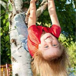 pige hænger med hovedet nedad i et birketræ