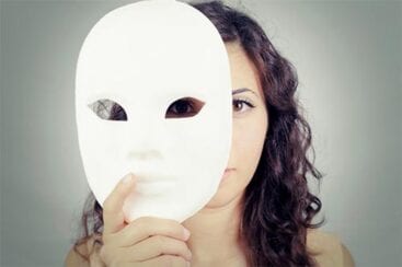 kvinde gemmer sig halvt bag hvid maske