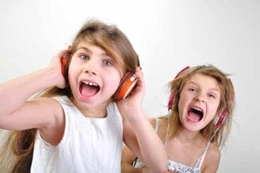 2 piger med høretelefoner på råber højt