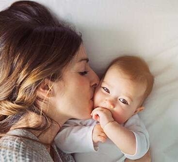 baby bliver kysset på kinden af sin mor