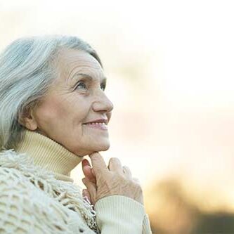 en ældre kvinde kigger opad og smiler