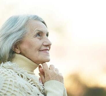en ældre kvinde kigger opad og smiler
